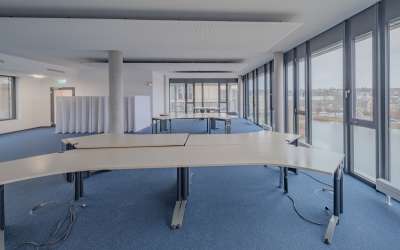 Großraumbüro in einer halben Etage - hier wird pefektes Arbeiten von makanter Architektur und Tageslicht unterstützt